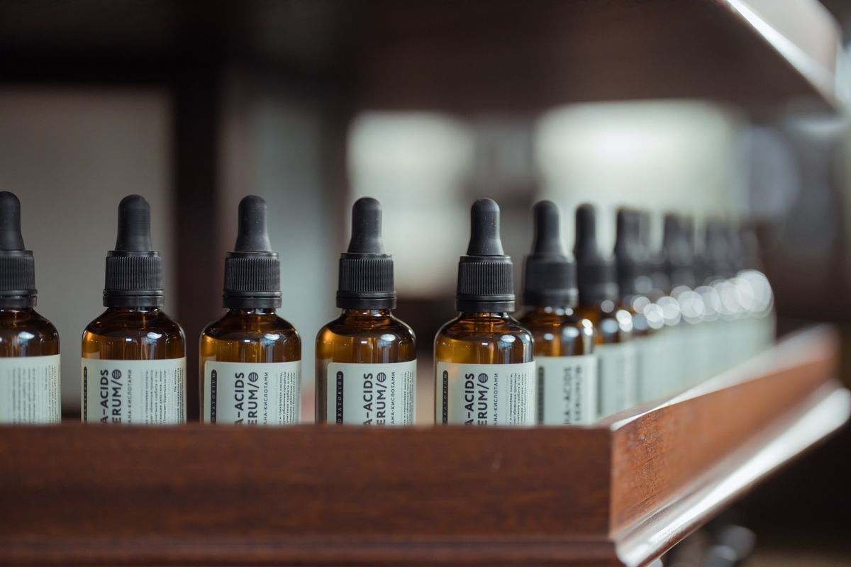 A row of brown serum bottles on a shelf, representing the serum-heavy side of Korean PDRN and peptide skincare trends.