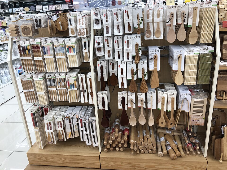 Wooden chopsticks, spoons, paddles, and small kitchen tools hanging inside Daiso Wonju Musil.