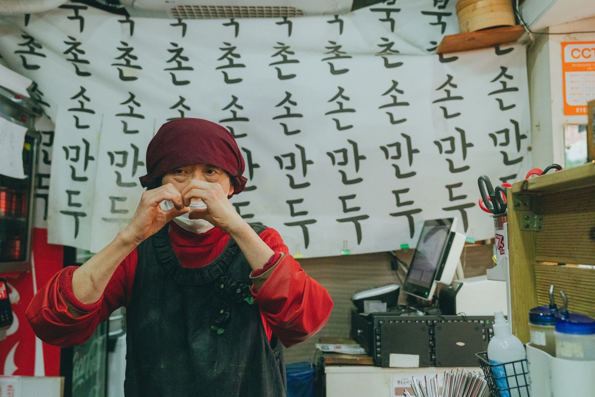 A Seoul food stall with Korean writing and a vendor, showing the savory side of station and market snack culture.