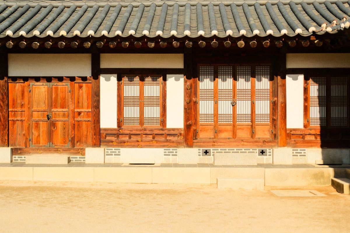 Traditional Korean hanok facade with wooden doors and tiled roof.