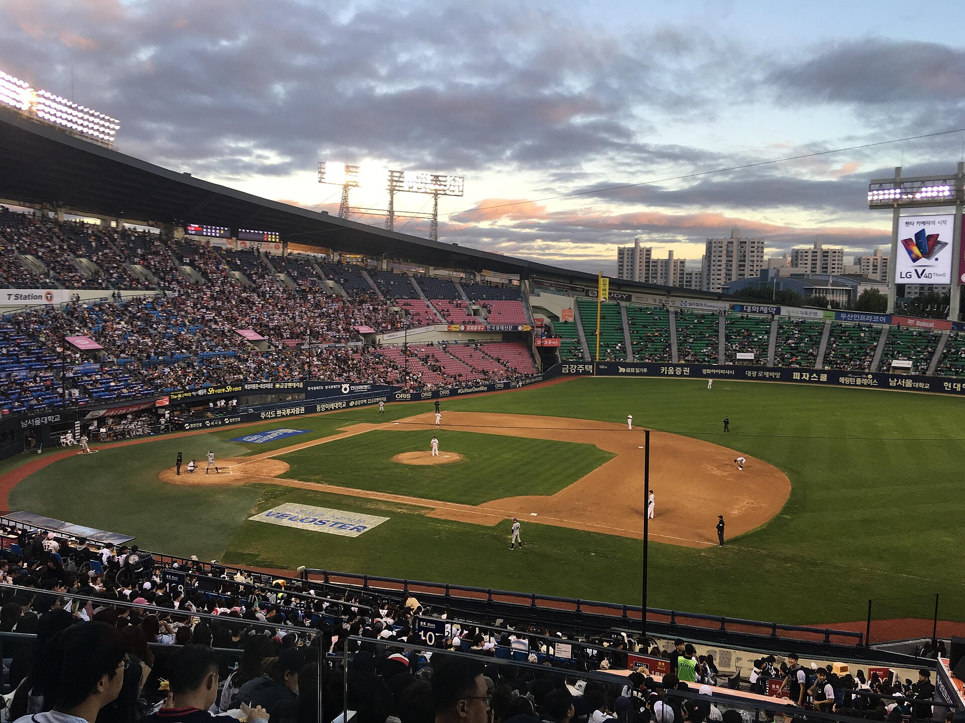 A wide view of Jamsil Baseball Stadium at dusk during a Doosan Bears vs LG Twins game.