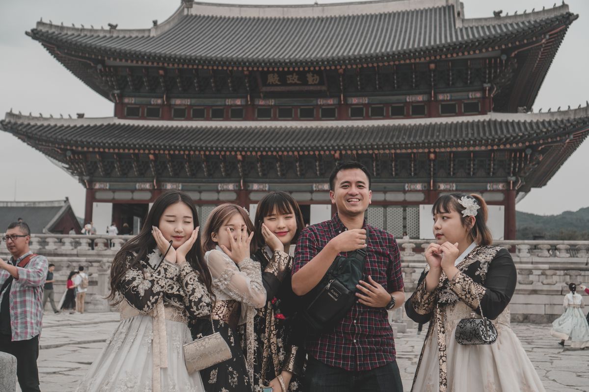 A group of visitors taking hanbok photos at Gyeongbokgung Palace.