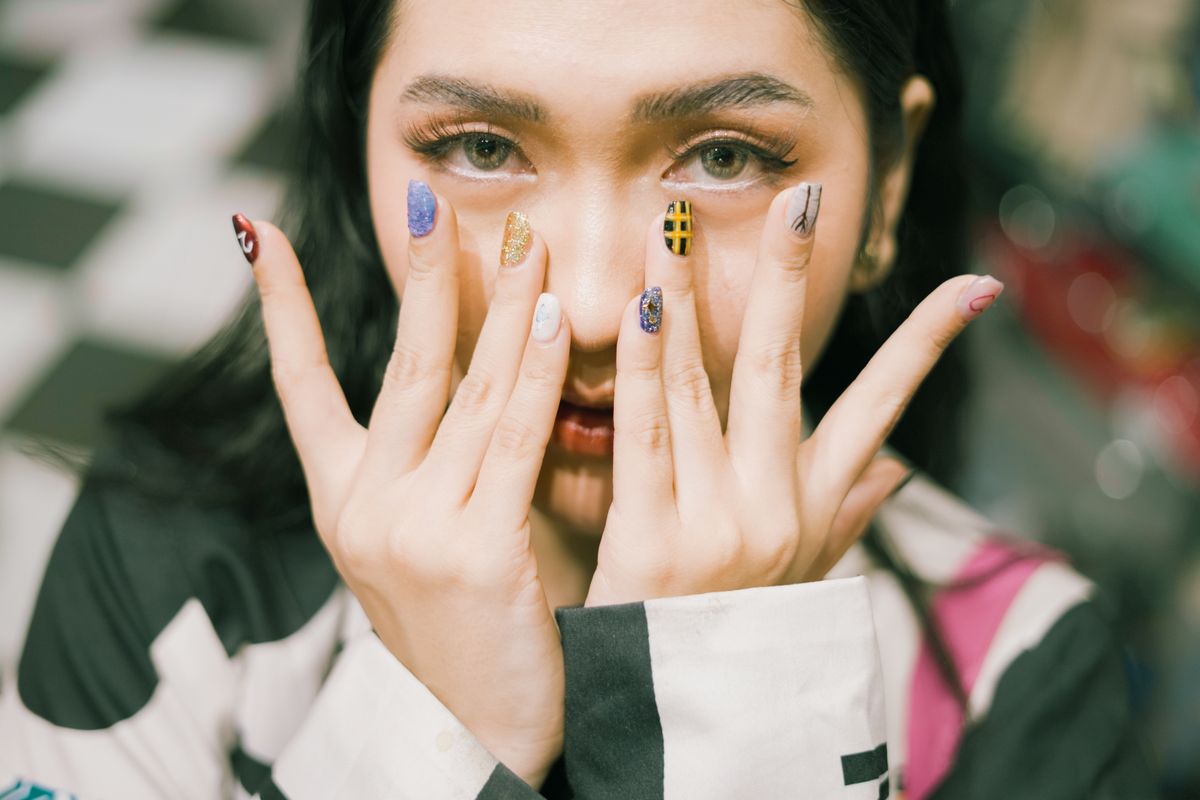 A close-up of colorful acrylic nail art used as design inspiration.