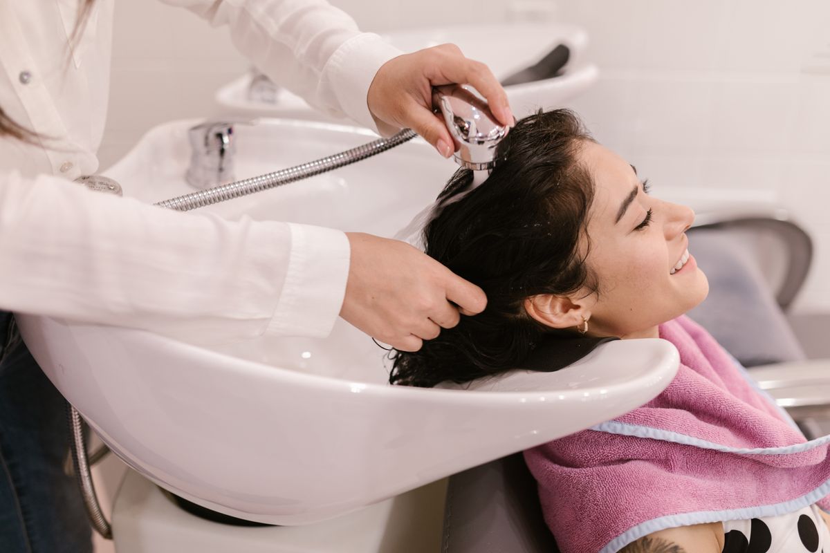 A woman receiving a salon hair wash and treatment.