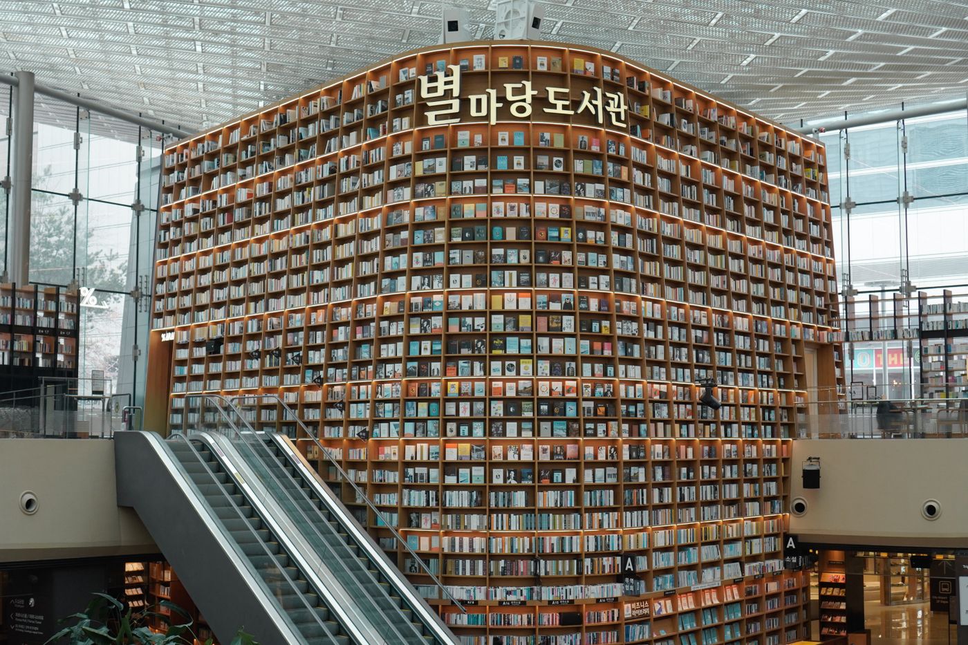 A dramatic Seoul library interior with tall shelves, showing Korea's public-facing focus-space aesthetic.