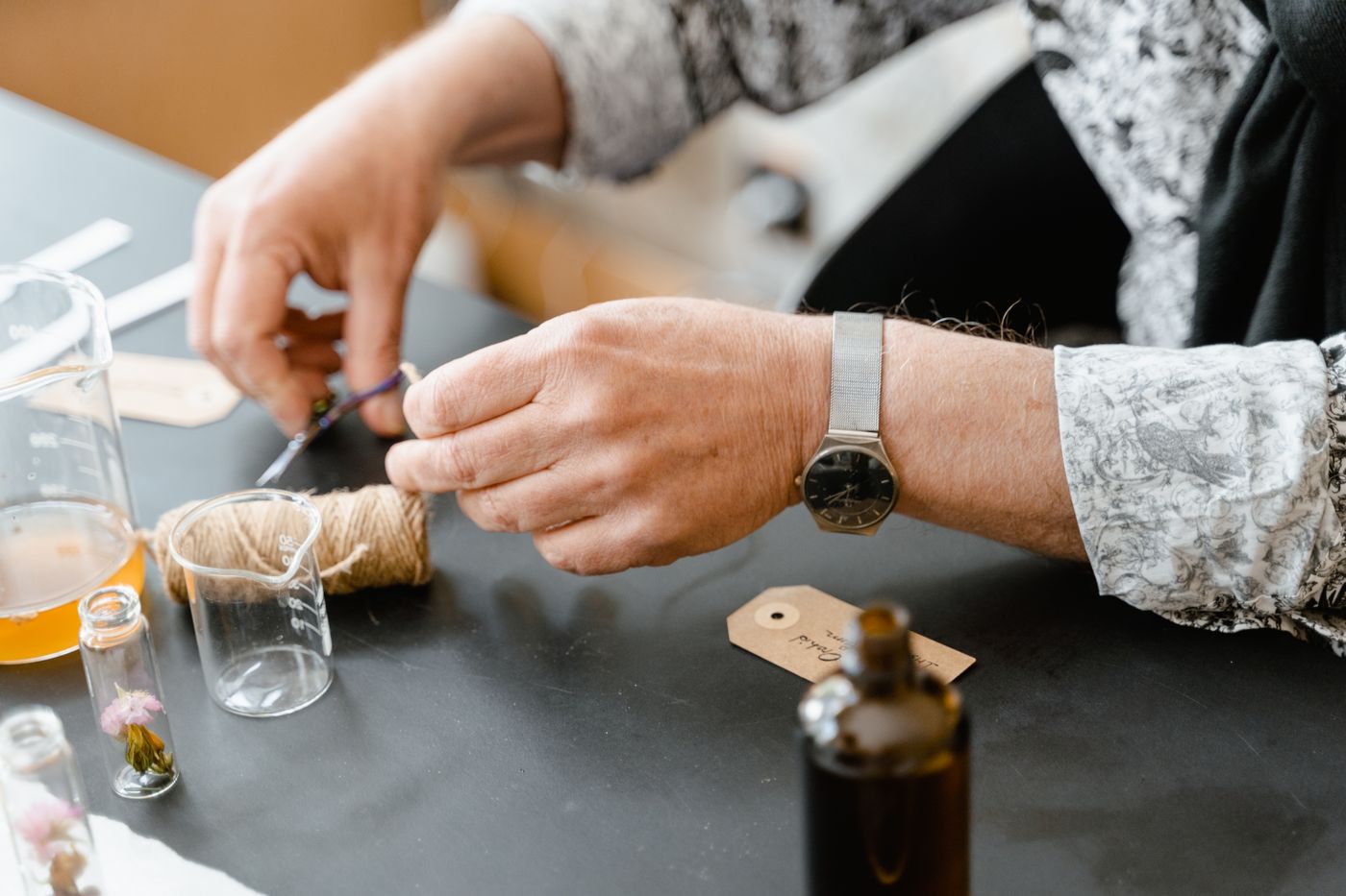 Hands blending scent ingredients and bottles, similar to Seoul perfume-making class setups.
