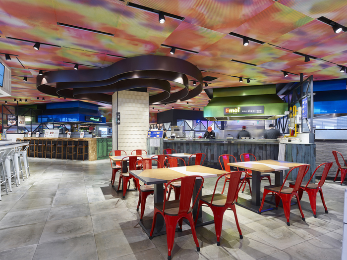 An indoor Lotte Food Avenue seating and restaurant counter area, showing why department-store food halls work as rainy-day routes.