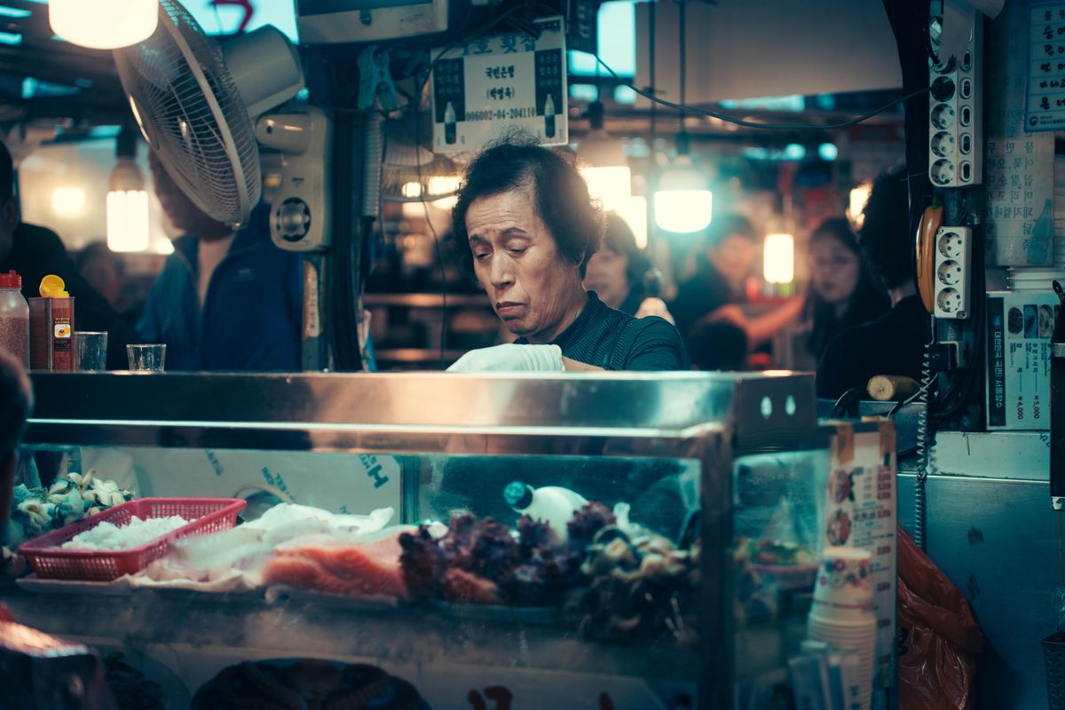 A Seoul market stall with Korean food and produce, showing the local-food context that polished department-store basements organize indoors.