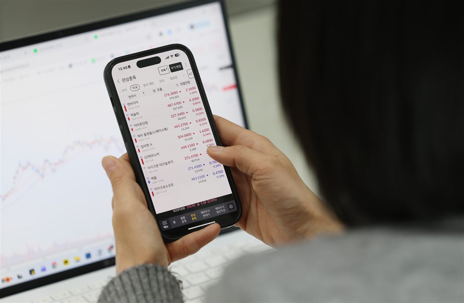 A Korean investor checks major U.S. stock listings on a smartphone brokerage app.