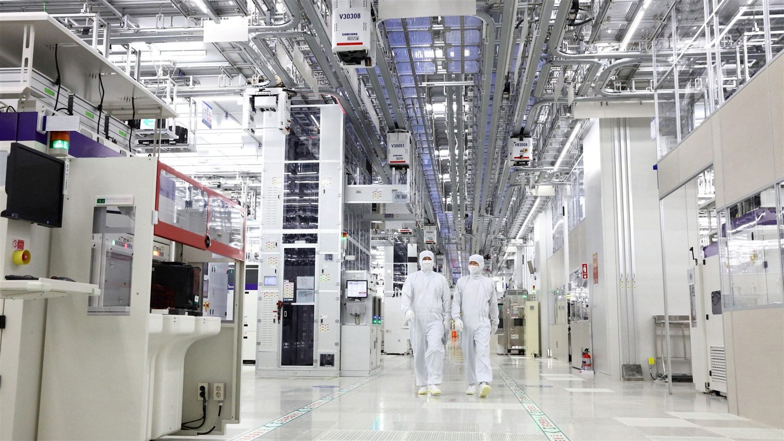 Two technicians walk through a Samsung Electronics semiconductor cleanroom in Pyeongtaek.