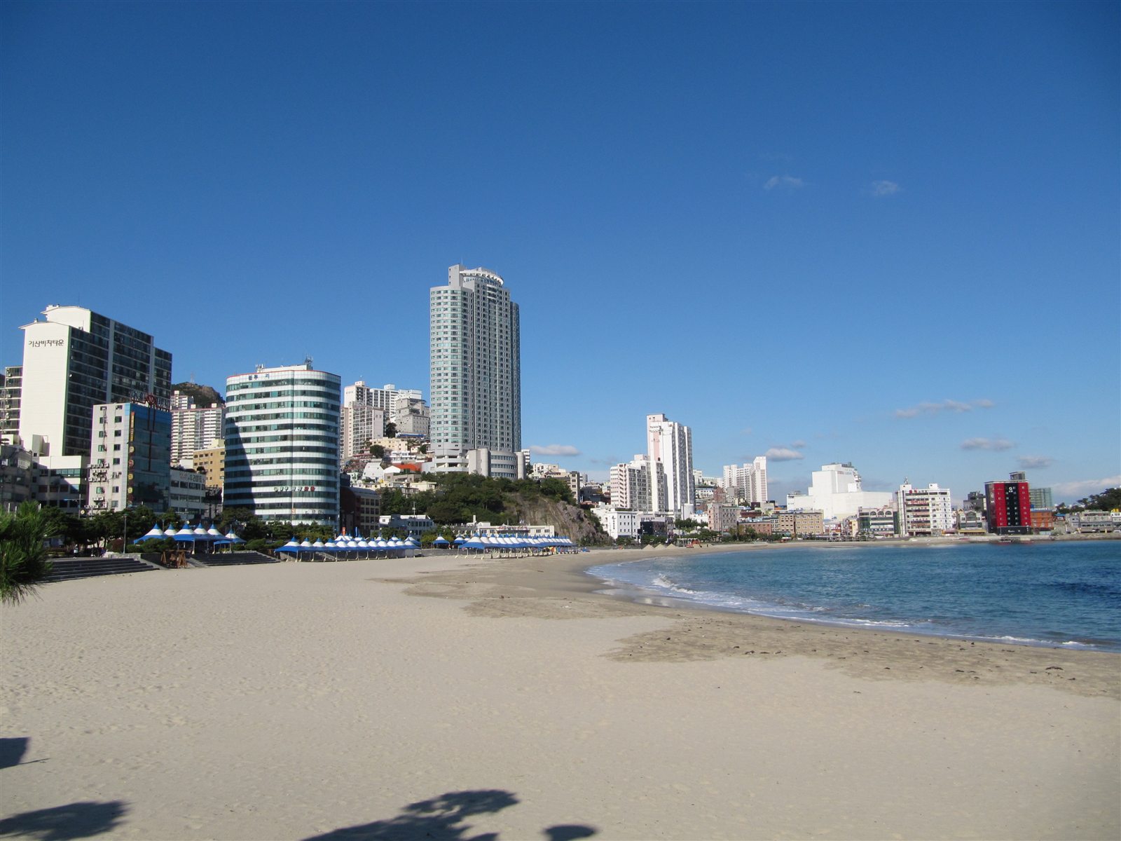 Songdo Beach in Busan with a wide shoreline and coastal city scenery.