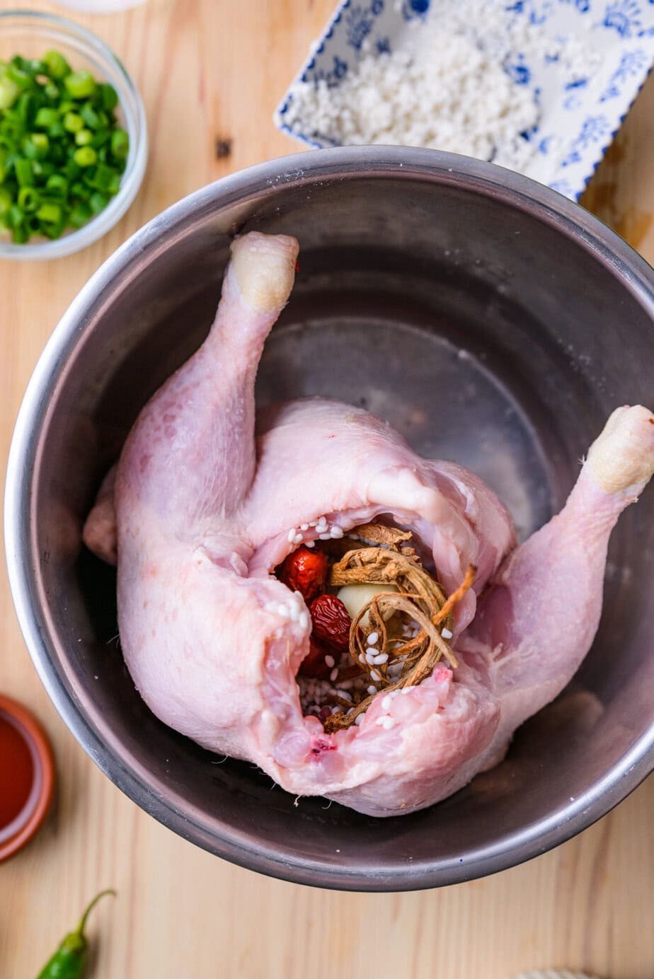A whole chicken is stuffed with rice, garlic, jujubes, and ginseng before simmering for samgyetang.