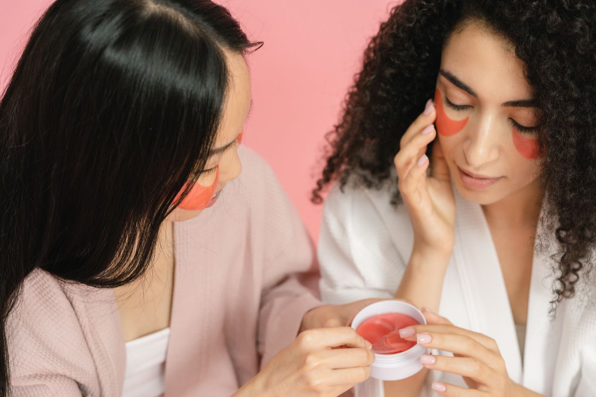 Two people applying under-eye patches during a skincare routine.