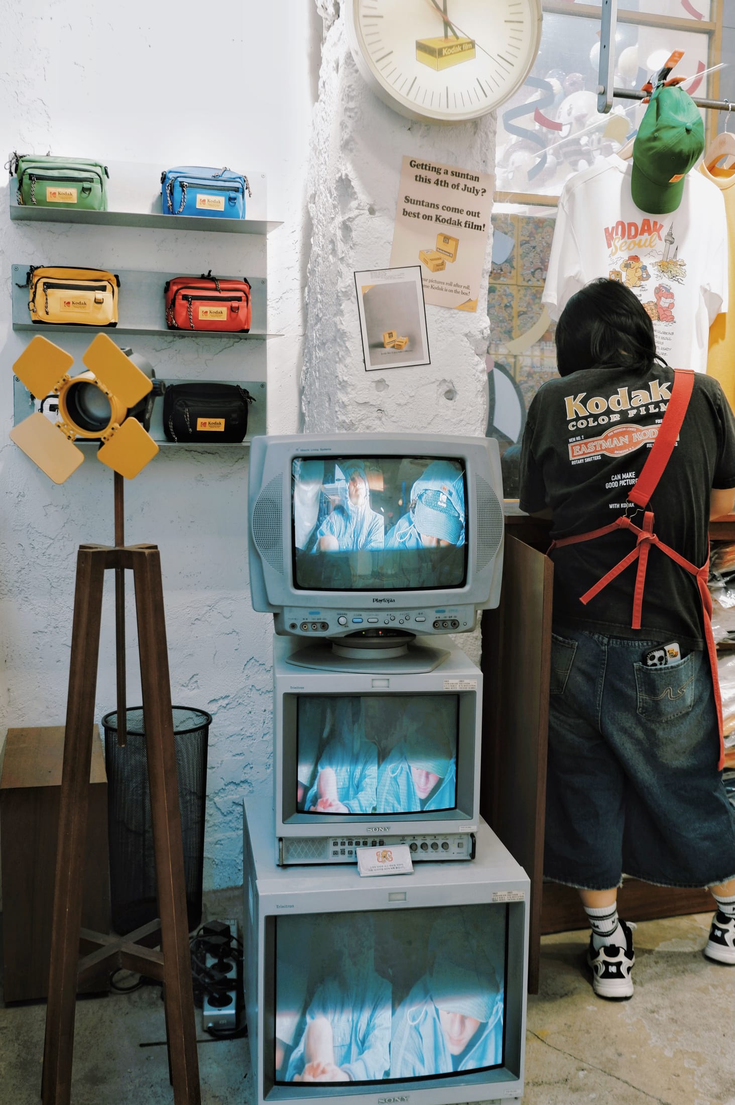 A retro Kodak-branded store interior in Seoul with a Kodak Seoul t-shirt display and vintage camera gear.