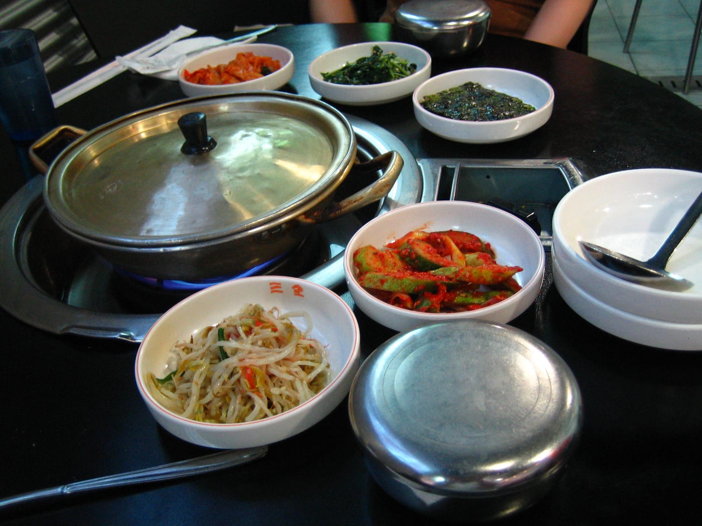 A Korean table with jjigae, rice, and banchan-style side dishes.