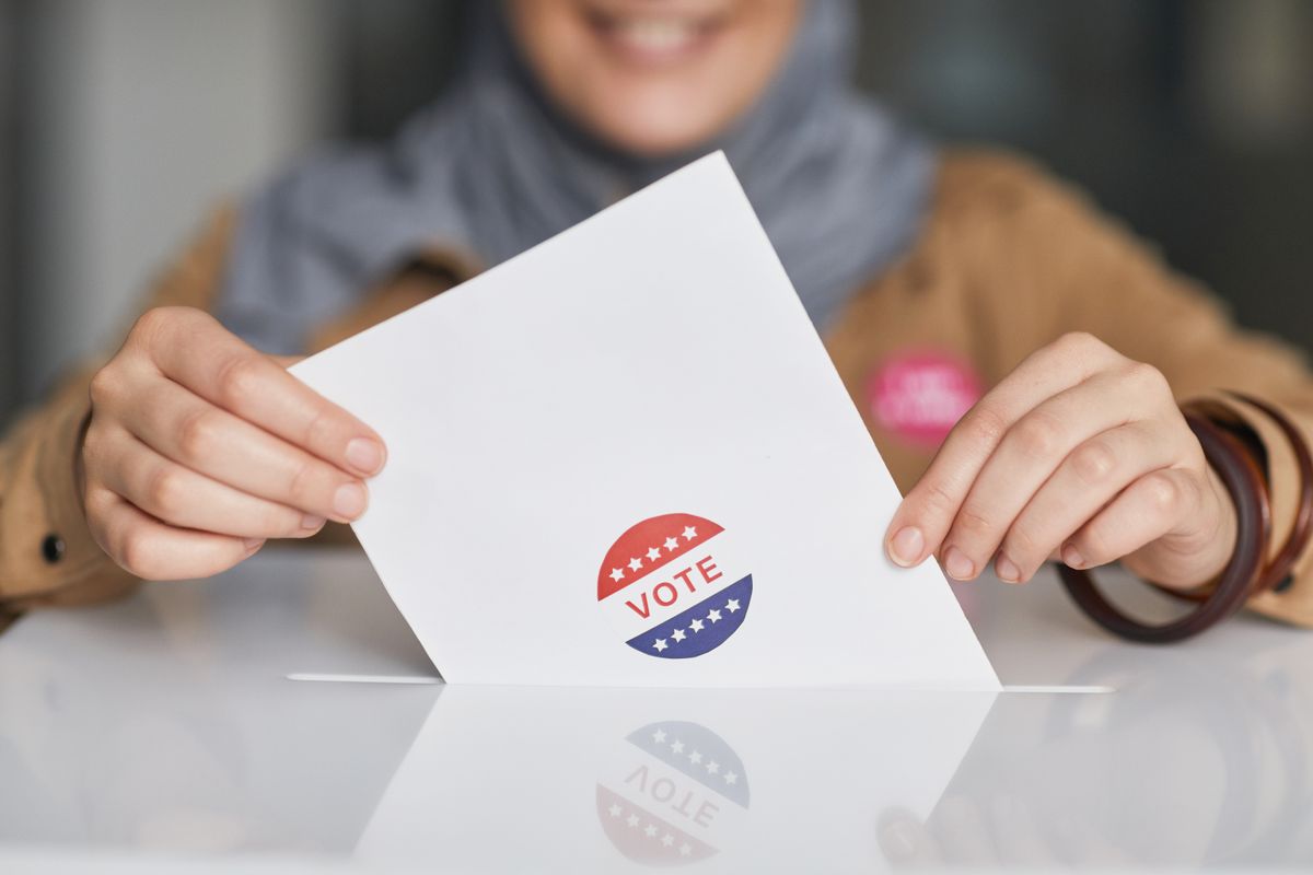Hands hold a ballot, representing how Korean party politics ultimately returns to voters and turnout.