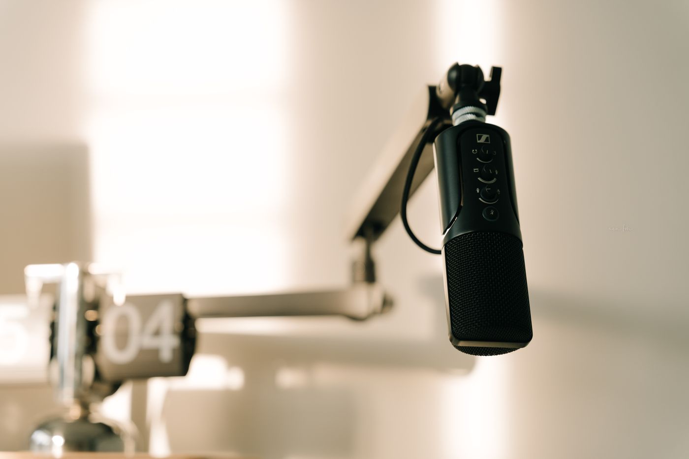 A close studio microphone, the visual shorthand of the video podcast format now common in creator channels.
