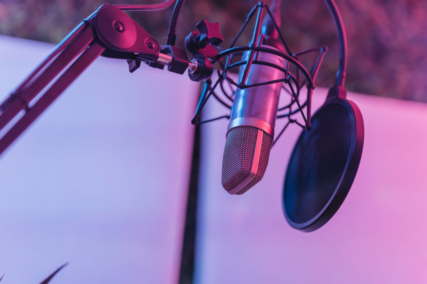 A studio microphone in a colorful recording space, matching the intimacy and set design of video-first podcast content.