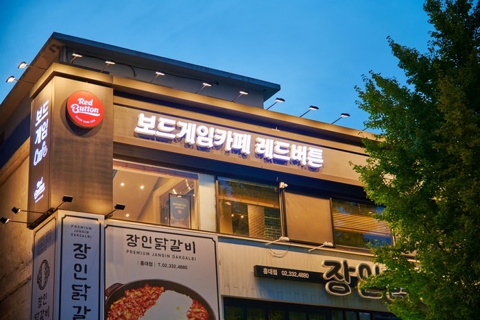 The Red Button board game cafe in Hongdae with a large Korean sign above the entrance.
