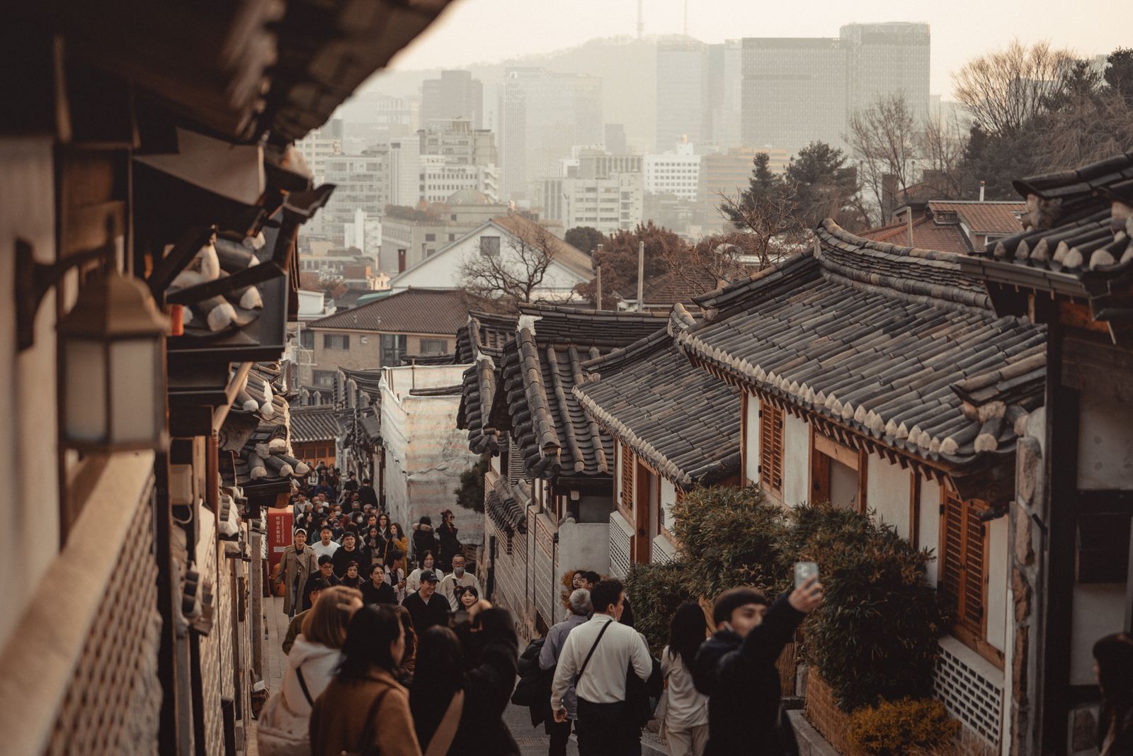 Visitors walking through a Bukchon hanok street.
