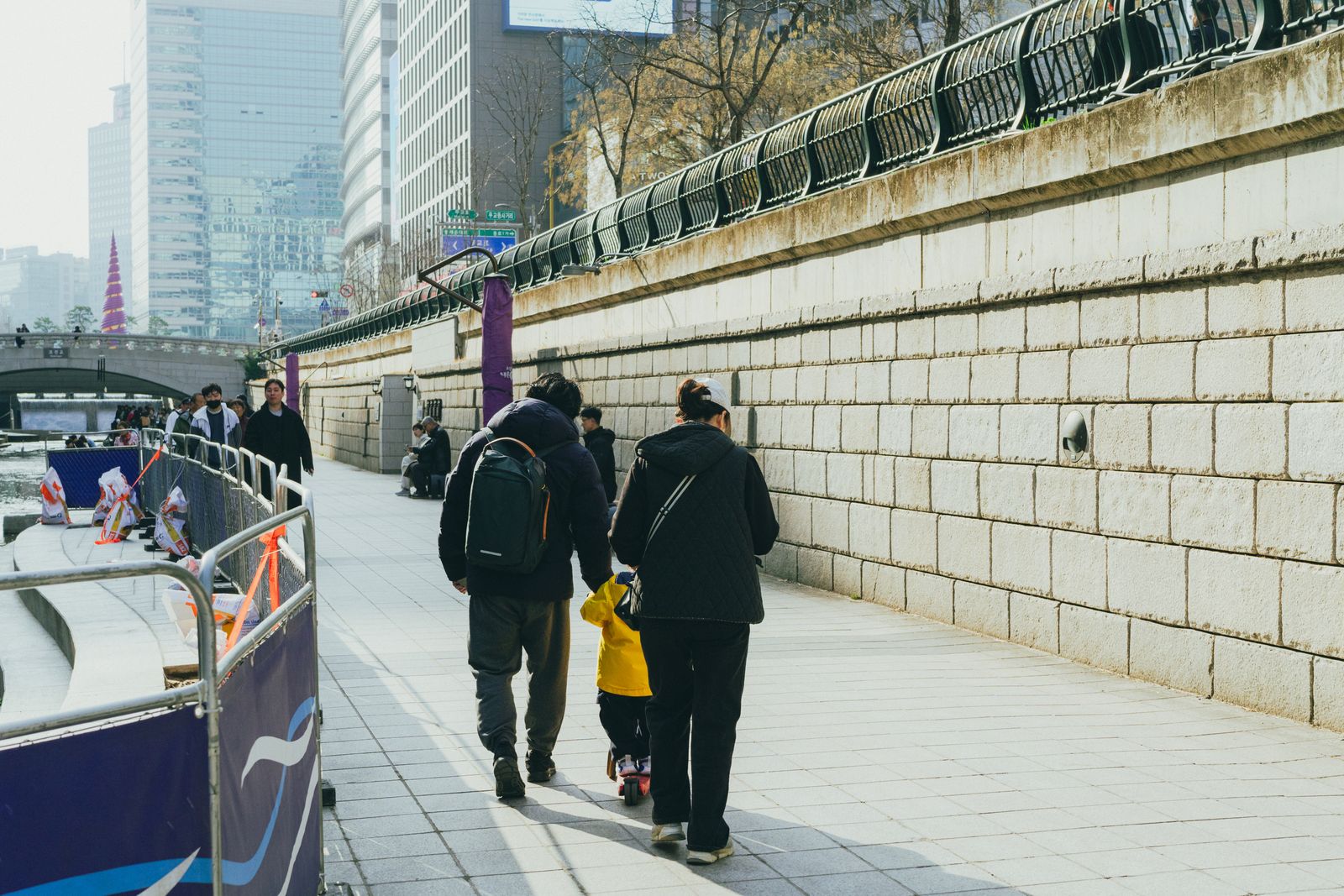 A family walking beside Cheonggyecheon Stream in central Seoul.