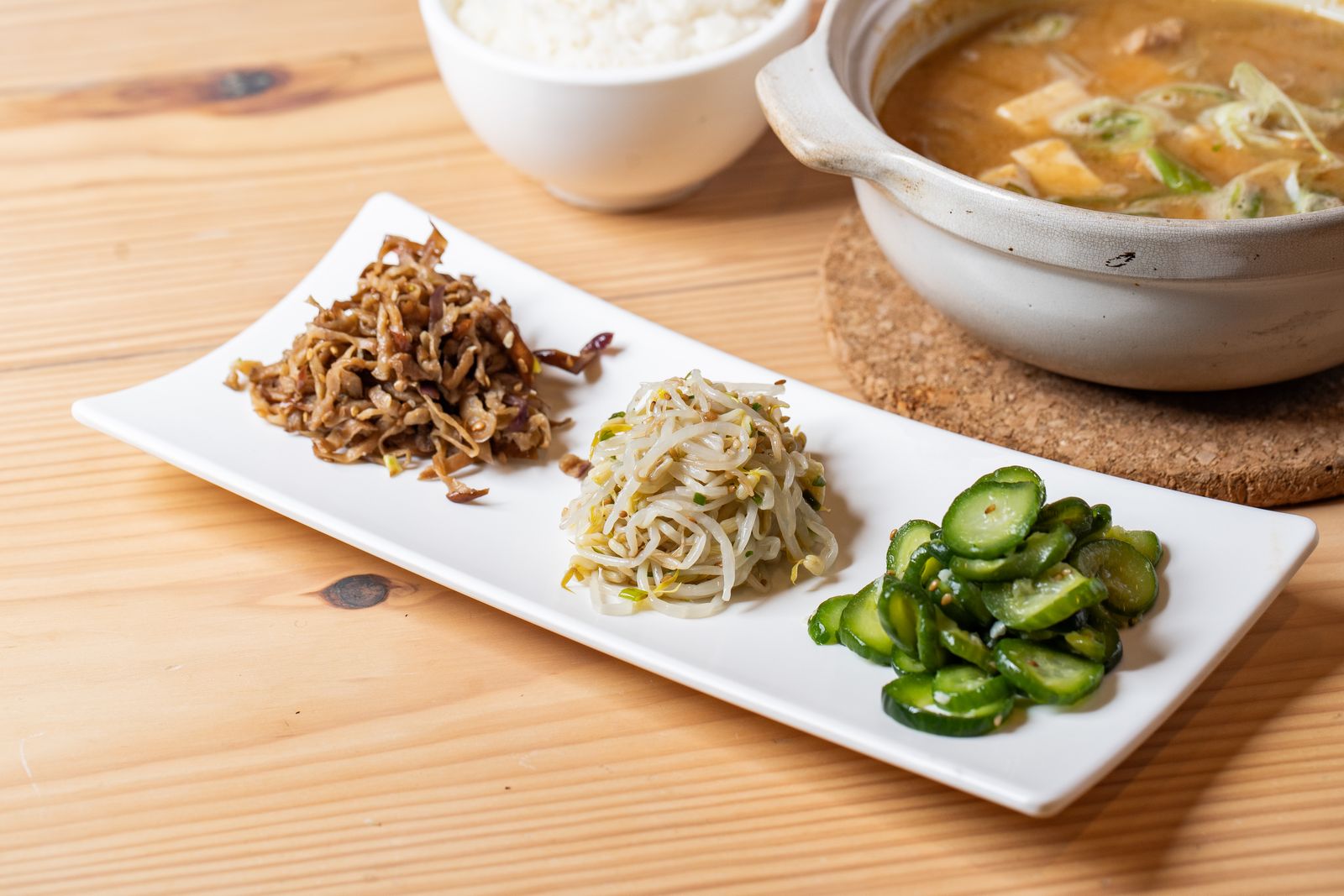 A Korean meal with rice, soup, and several banchan side dishes.