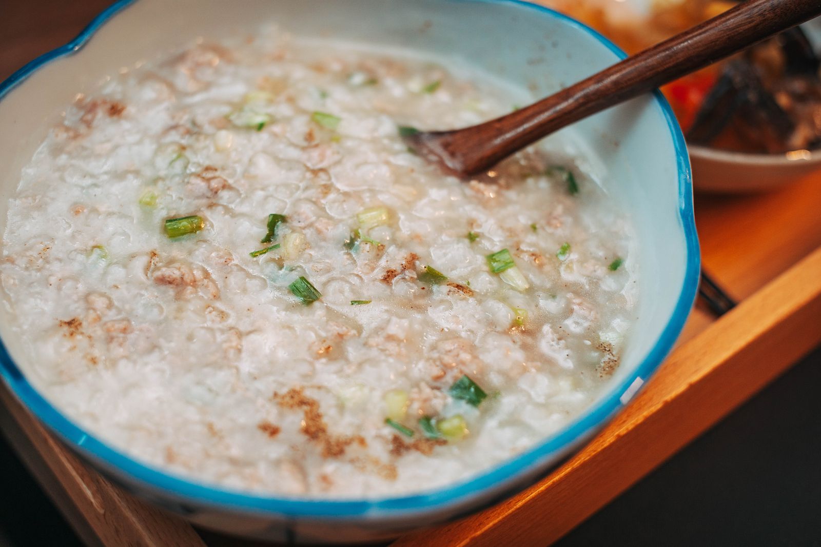 A close view of warm rice porridge with scallions.
