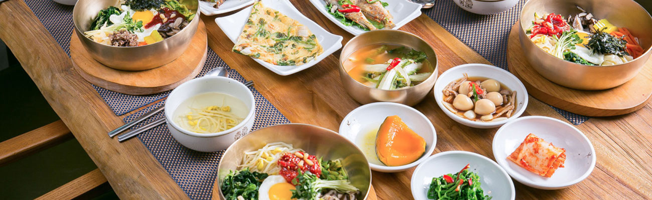 A Jeonju table presents bibimbap with soup and multiple side dishes.