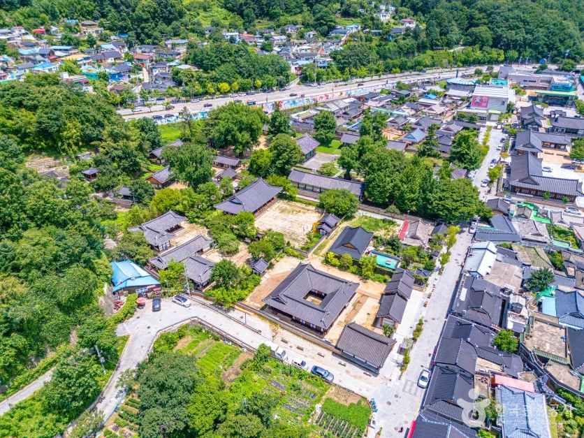 An aerial view shows Gyeonggijeon and the dense urban fabric around Jeonju Hanok Village.