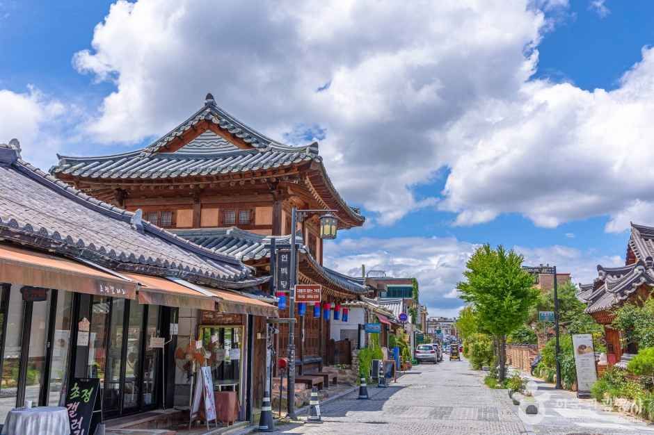 A quieter Jeonju Hanok Village street shows shops, tiled roofs, and an open walking route.