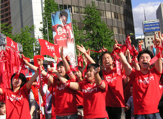 Korean football supporters in red shirts cheering the national team in 2006.