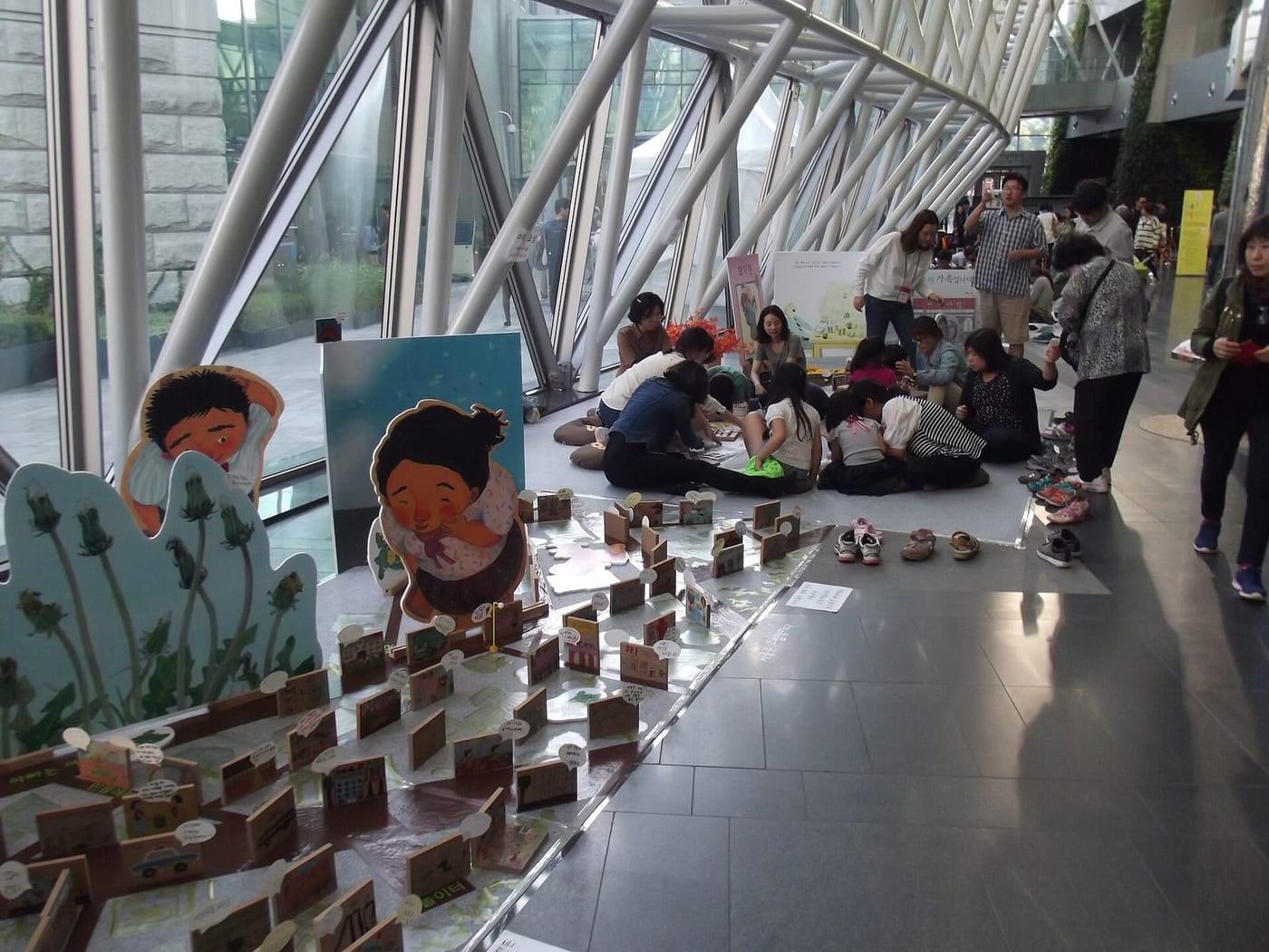 Children and parents doing a floor craft activity in an indoor public space at Seoul City Hall.