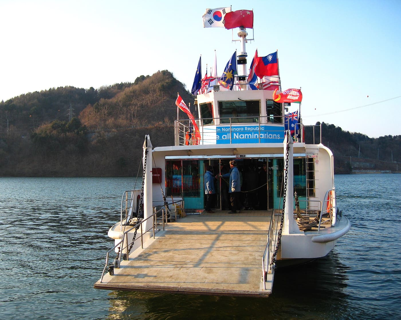 The Nami Island ferry with flags and a "Naminara Republic" banner crossing the lake.