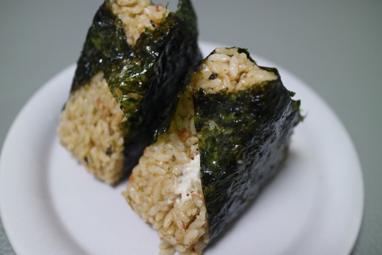 A second real Korean triangular kimbap, unwrapped, showing the seaweed and rice.