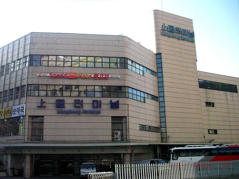 The Sangbong Bus Terminal building in Seoul in 2009, with the lettering 上鳳터미널 SangBong Terminal on its front and a bus parked outside.