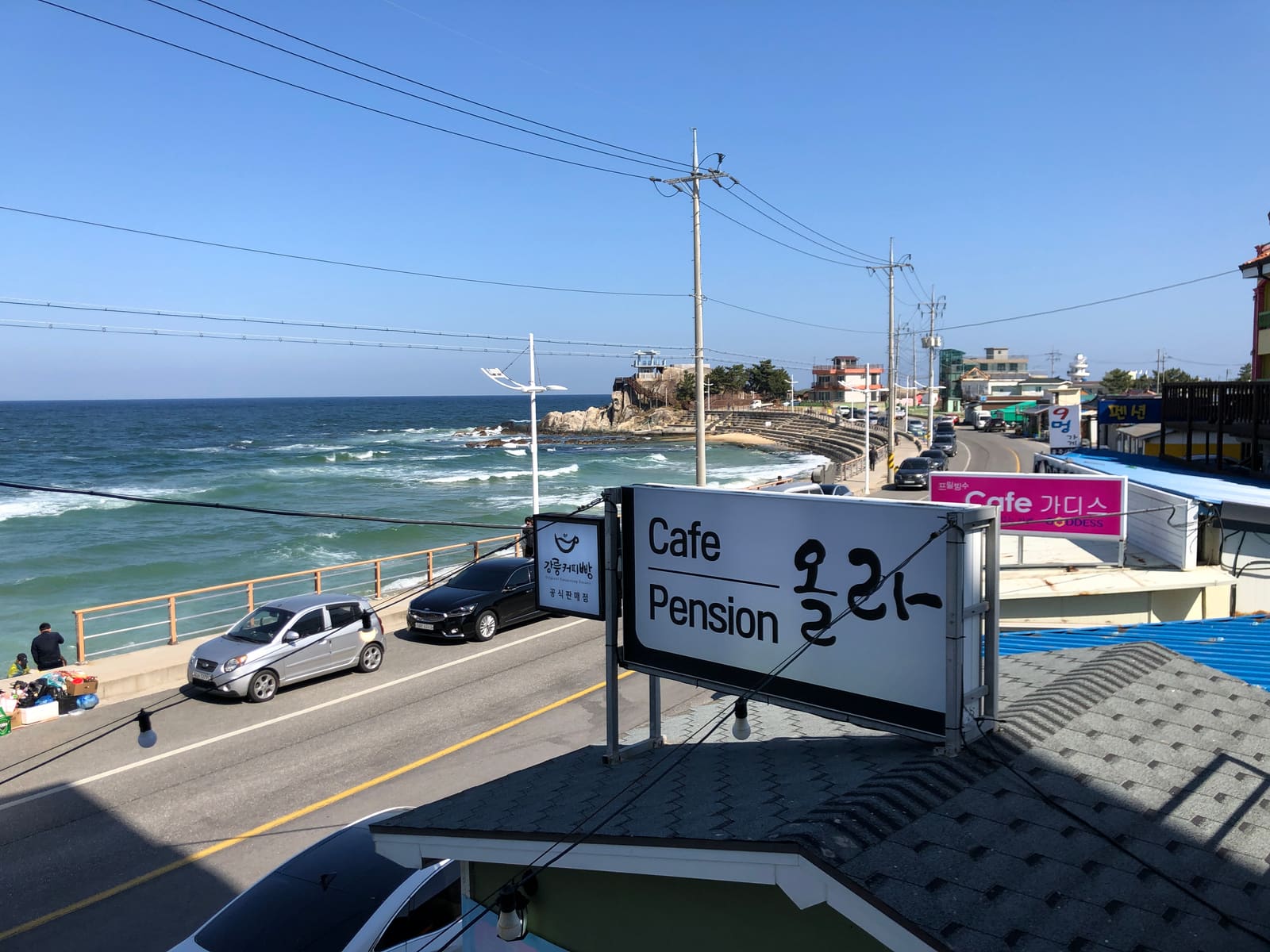 The Jumunjin coastal road, with the East Sea and rocky shoreline, cafes and pensions lining the street.