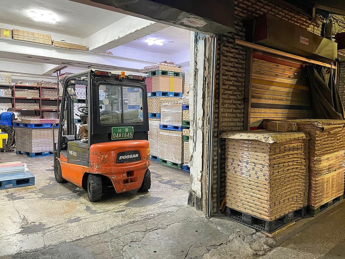A paper wholesaler in Euljiro's printing alley, stacks of paper stock filling the shopfront.