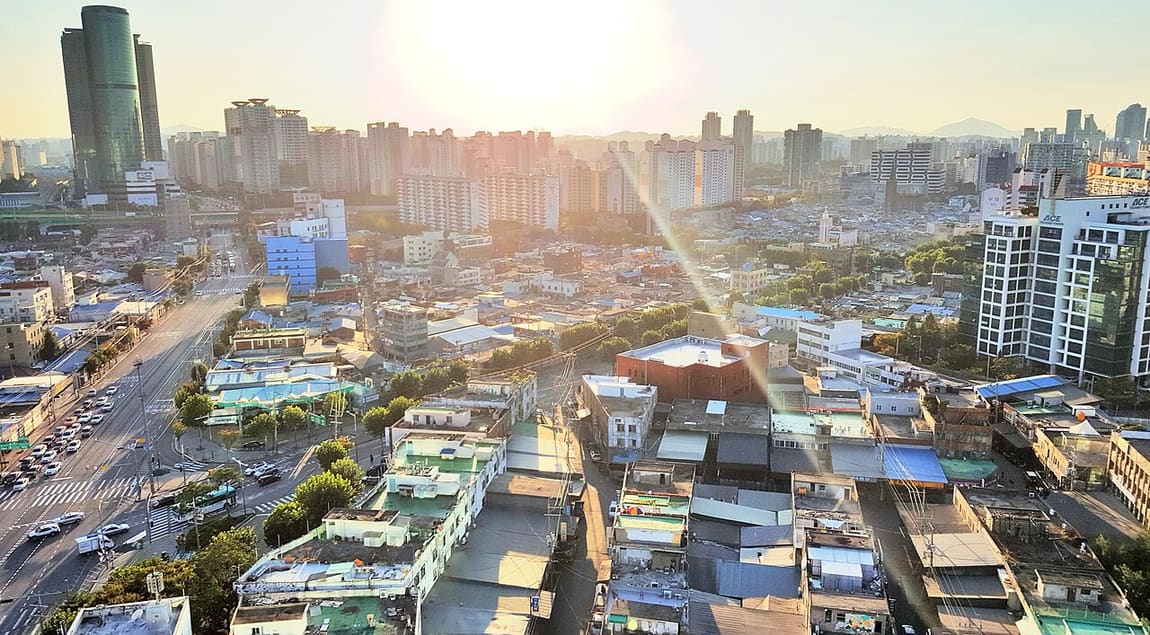 Low-rise Mullae rooftops with high-rise apartments and office towers directly behind.
