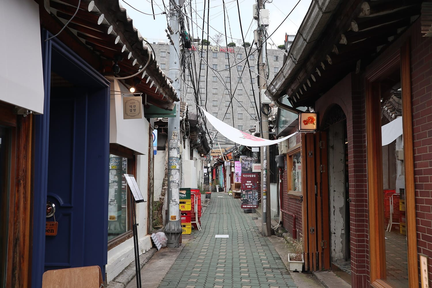 A narrow alley in Ikseon-dong lined with single-storey hanok, tiled roofs meeting overhead.