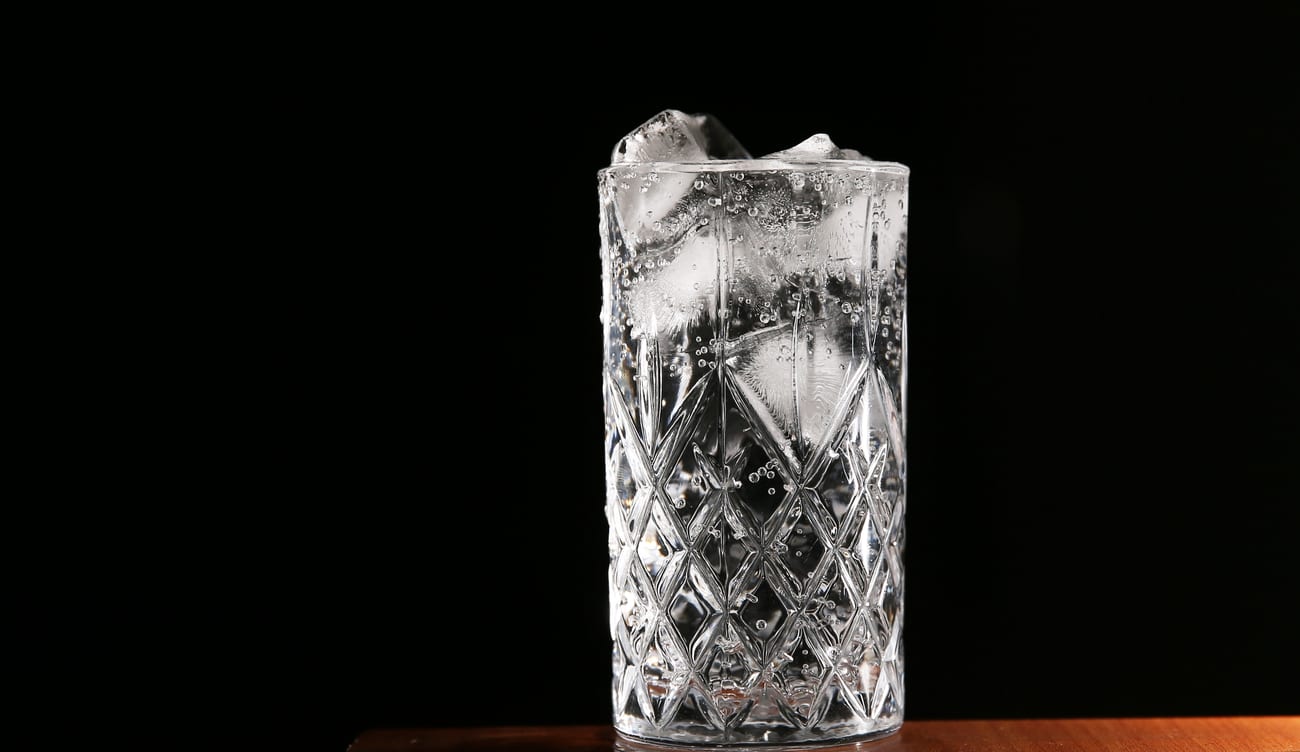 A tall cut-glass tumbler of Chilsung Cider over ice — completely clear and colourless.