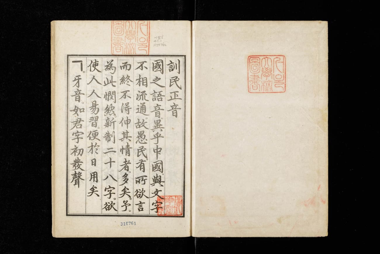 The opening pages of the Hunminjeongeum Haerye, printed in vertical columns of classical Chinese with red collection seals, beginning with the title 訓民正音.