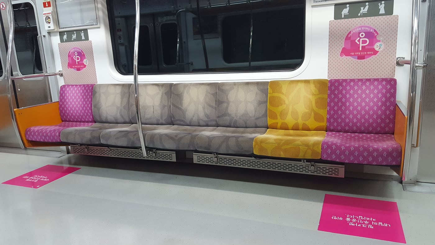 Pink priority seats for pregnant passengers on Seoul Metro Line 1, marked with a pregnancy pictogram and Korean signage.