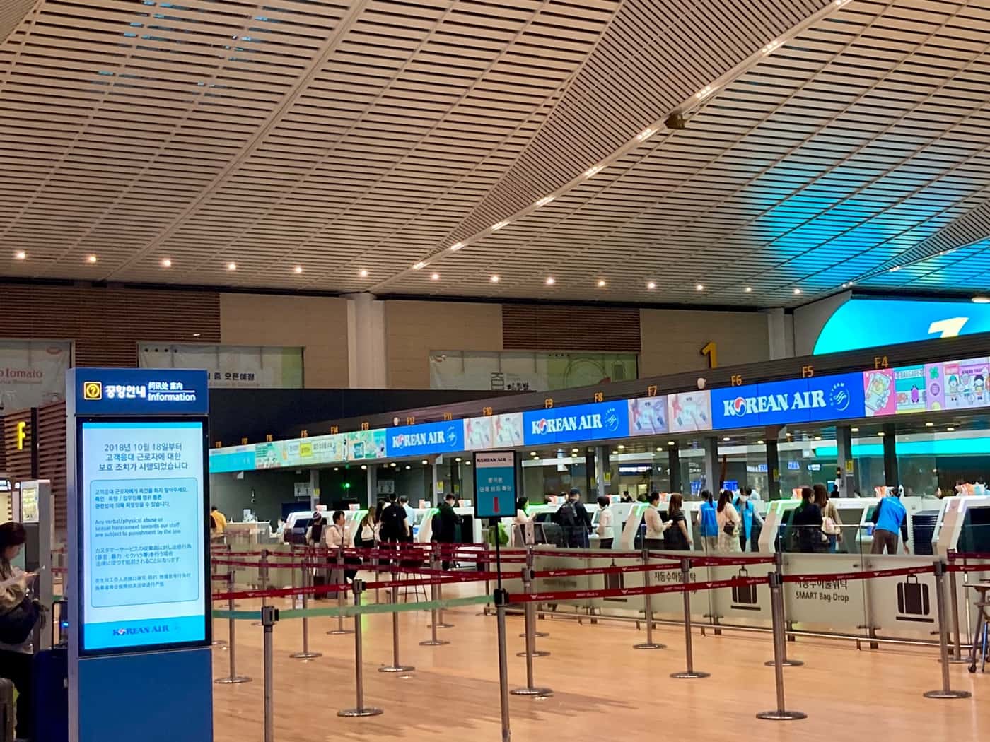 Korean Air check-in counters at Incheon Airport Terminal 2, with blue KOREAN AIR signage above a row of desks and passengers queueing behind stanchions.