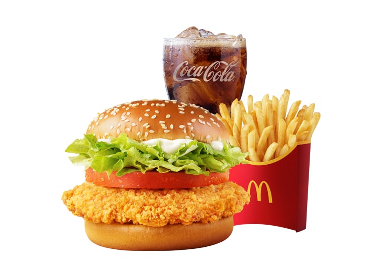 The McSpicy Shanghai Burger meal on a white background: a chicken fillet burger with lettuce in a sesame bun, beside a red carton of fries and a Coca-Cola.