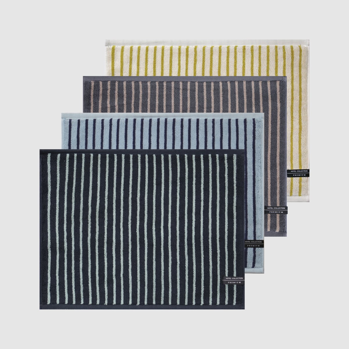 Four striped Songwol Hotel Collection towels laid in an overlapping fan, each with a small black woven HOTEL COLLECTION PREMIUM label at the corner.