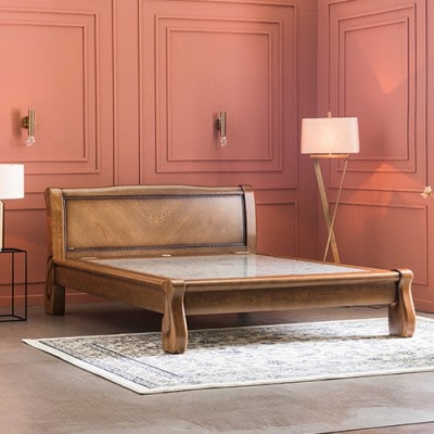 An ornate wooden Korean stone bed in king size, with a stone sleeping surface set into a carved sleigh-style frame.
