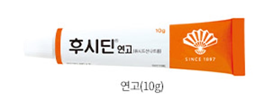 An orange and white tube of Fucidin ointment, 10g, from Dongwha Pharm, with the Korean product name 후시딘연고 and the company's SINCE 1897 mark.