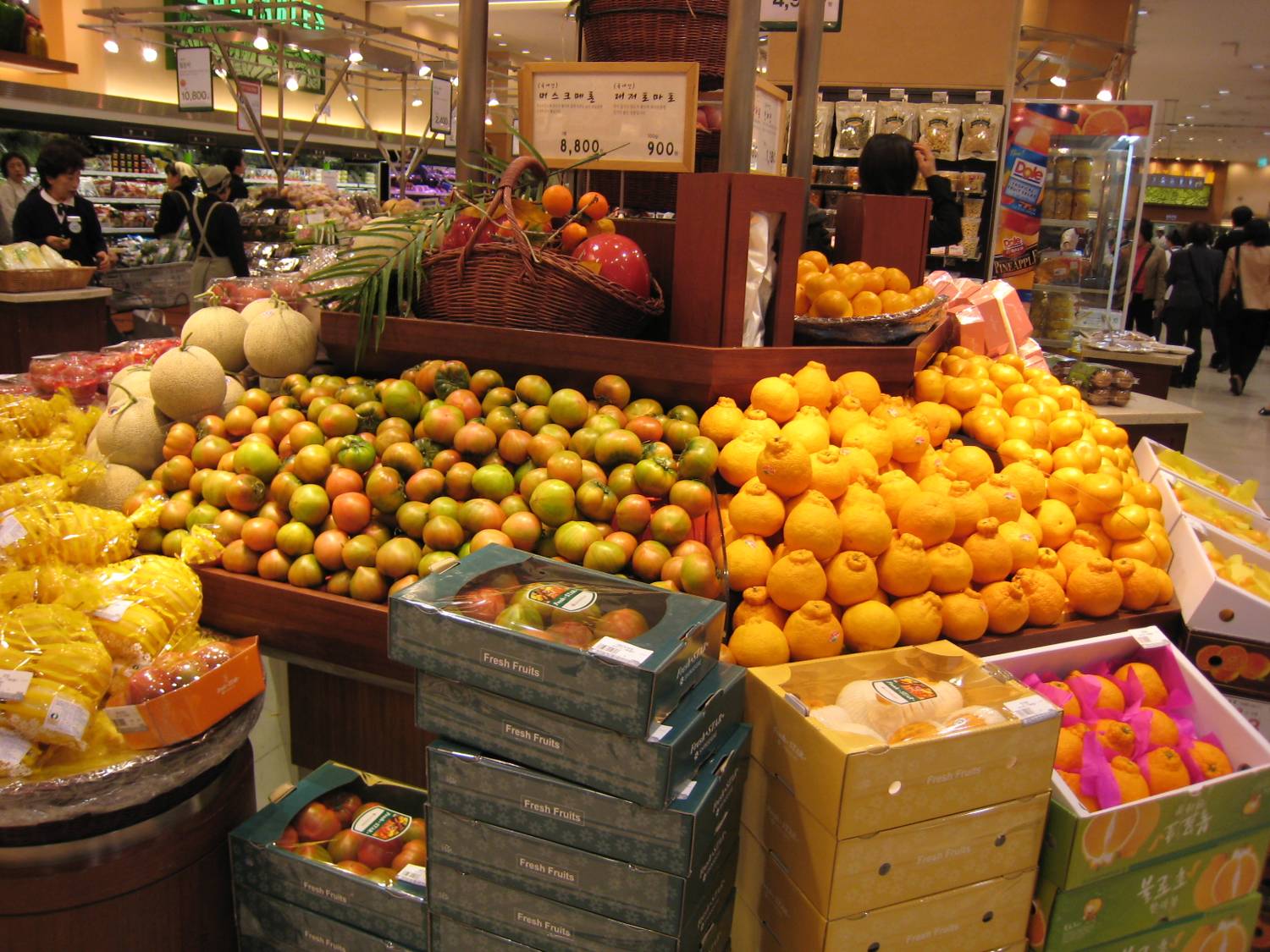 Hallabong citrus and boxed fruit gift sets stacked in a Seoul department-store food hall.