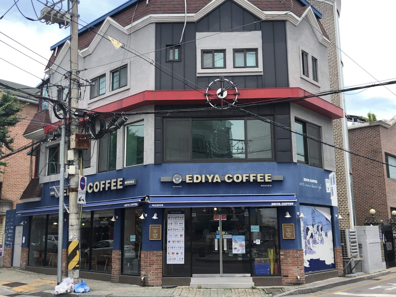 An Ediya Coffee shop on a street corner in Jecheon, blue sign, two storeys, on a quiet residential street.