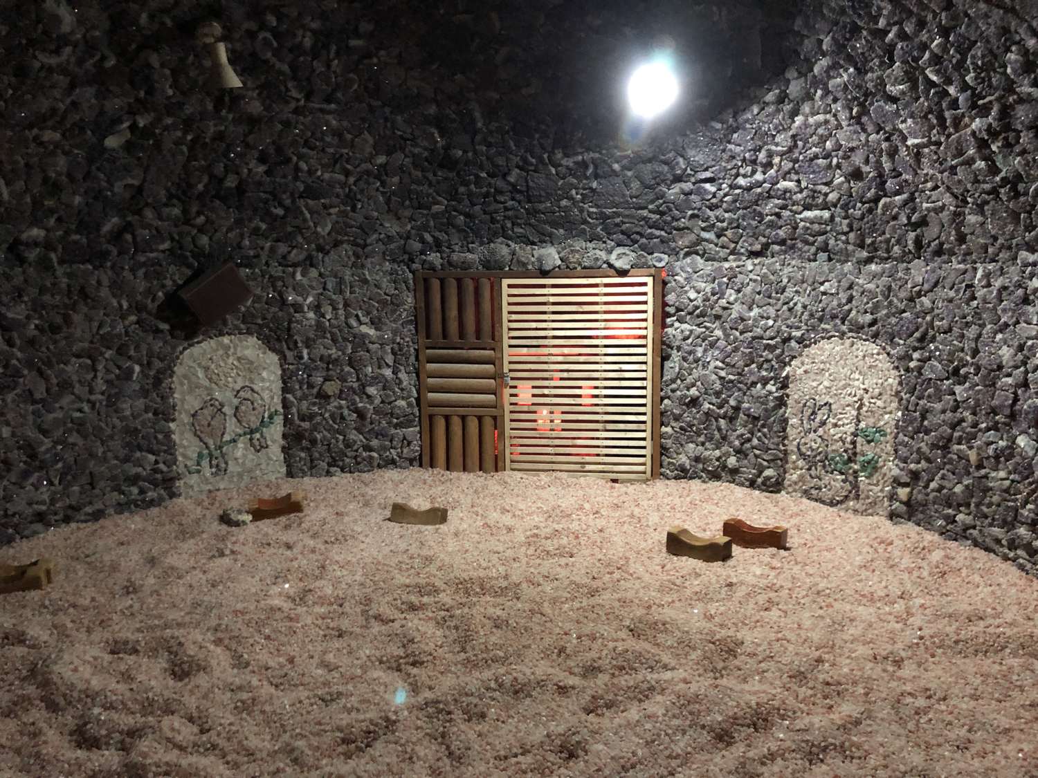 A stone-lined kiln sauna room, the bulgama, with a wooden door and a floor of crushed rock, at a 24-hour sauna in Wonju.
